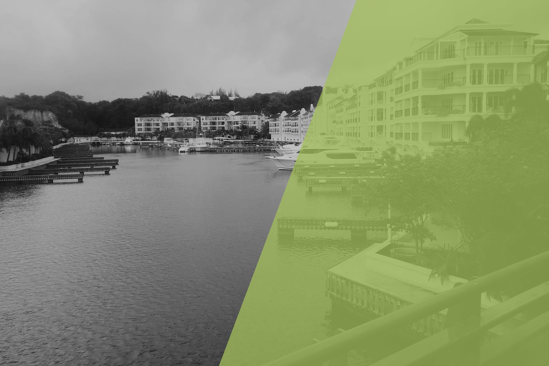 black and white photo of ocean front buildings with docked boats